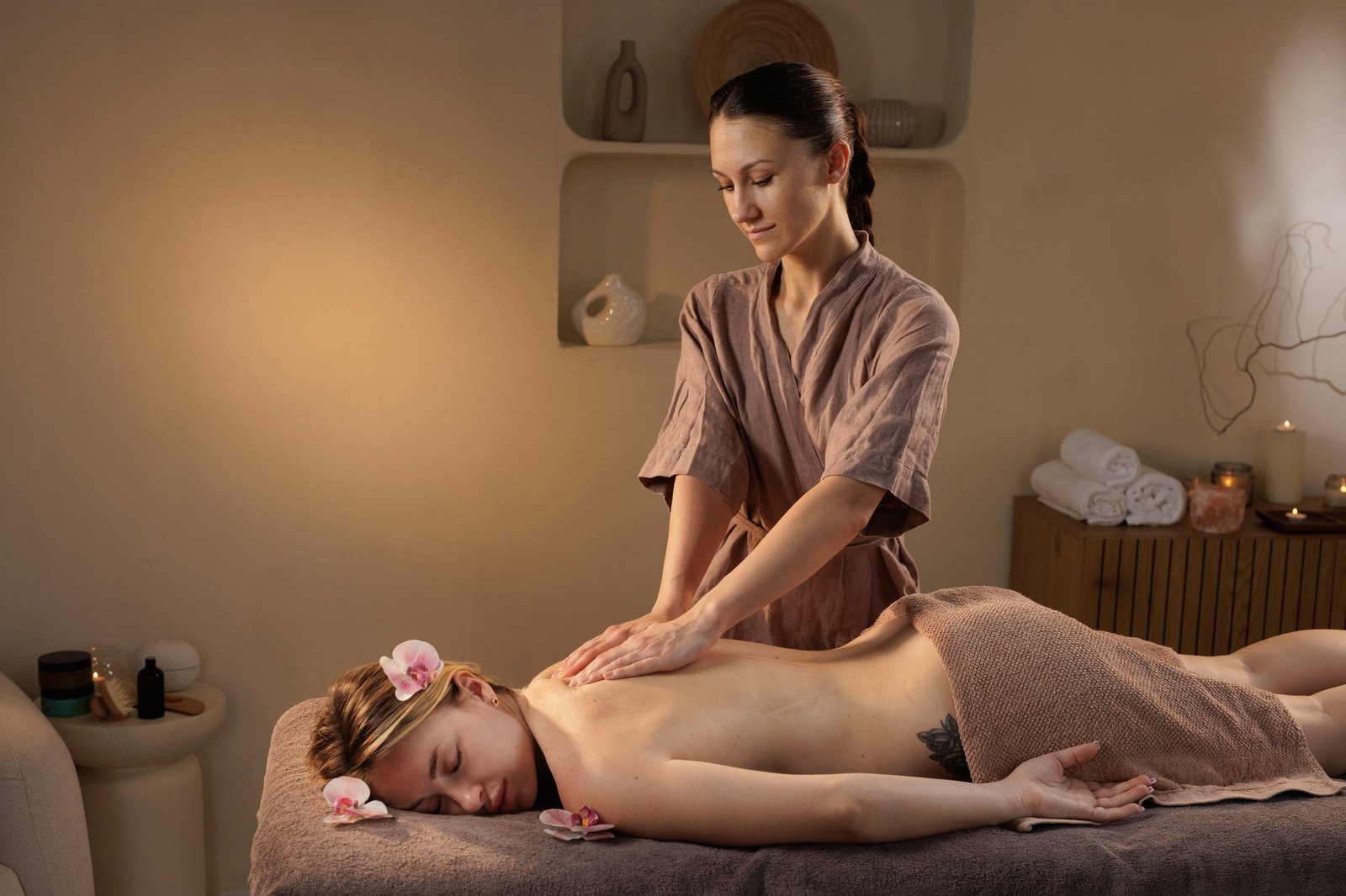 Relaxing back massage in serene spa setting with flower petals and calming ambiance.